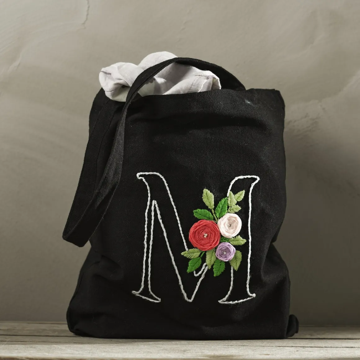 Broder et handlenett i tekstil, og gi det et personlig preg med bokstav og blomster